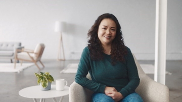 A woman sitting down, smiling.